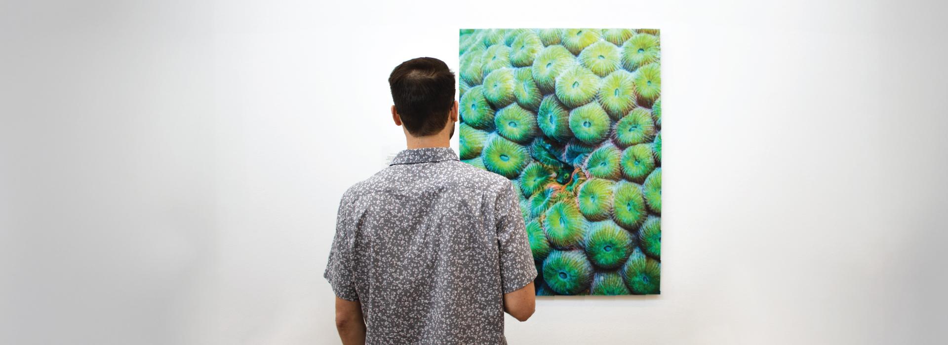 man looking at art print on the wall